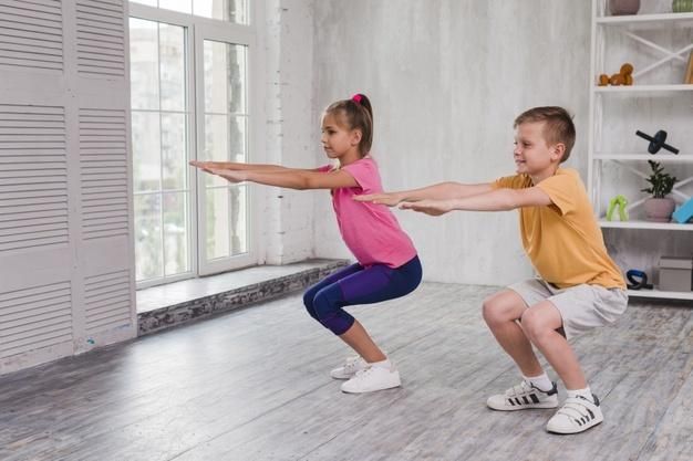 Portrait of a boy and girl exercising at home Free Photo